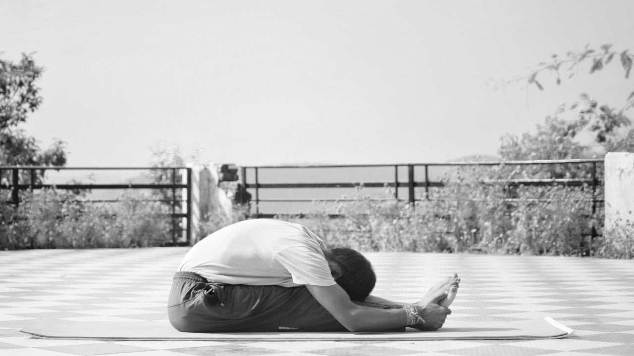 person stretching and wondering what causes foot pain