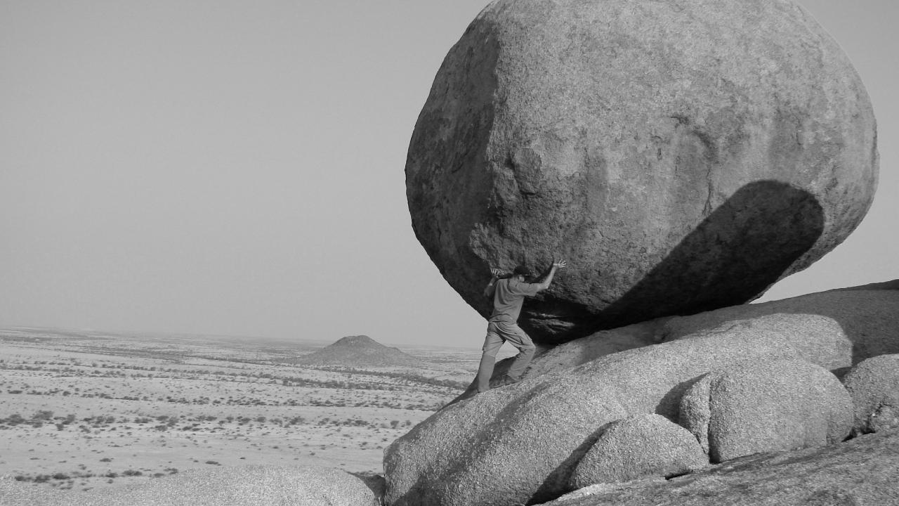 person pushing boulder and experiencing arch pain