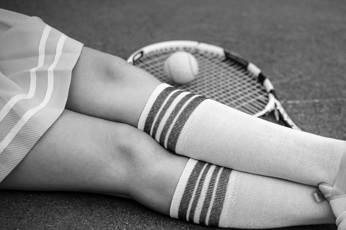 close up of tennis player knees - experiencing plantar fasciitis knee pain
